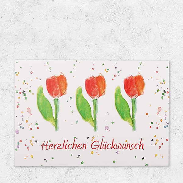 Eine Klappkarte, bedruckt mit Tulpen und der Aufschrift Herzlichen Glückwunsch.