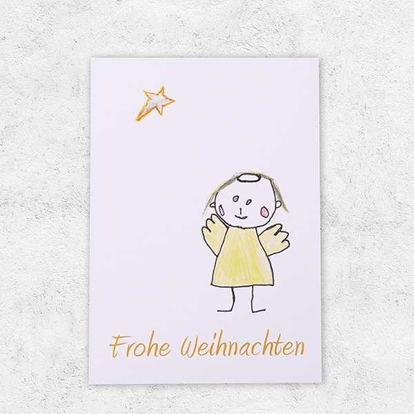 Eine Karte bedruckt mit einem Engel mit der Aufschrift Frohe Weihnachten.