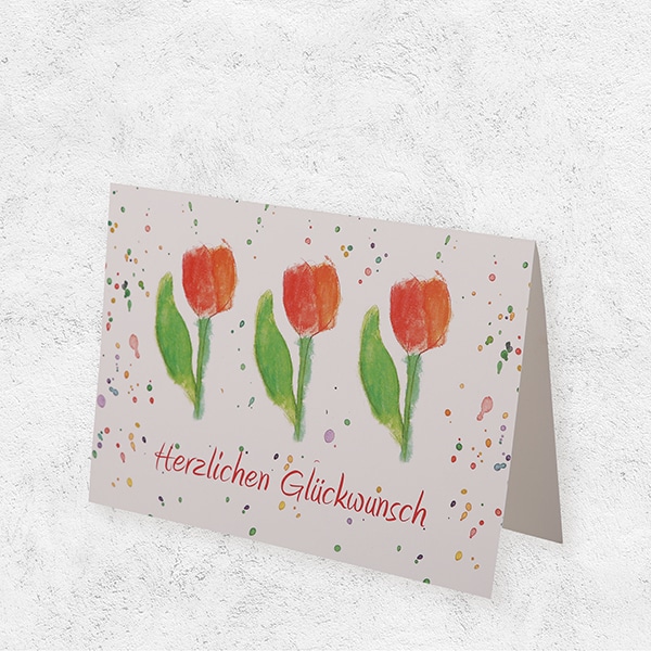 Eine Klappkarte, bedruckt mit Tulpen und der Aufschrift Herzlichen Glückwunsch.