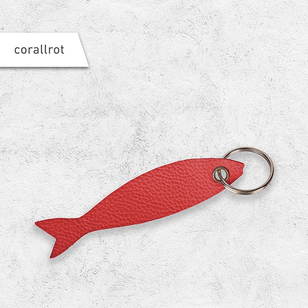 Ein Schlüsselanhänger in Fischform aus Leder in der Farbe corallrot.