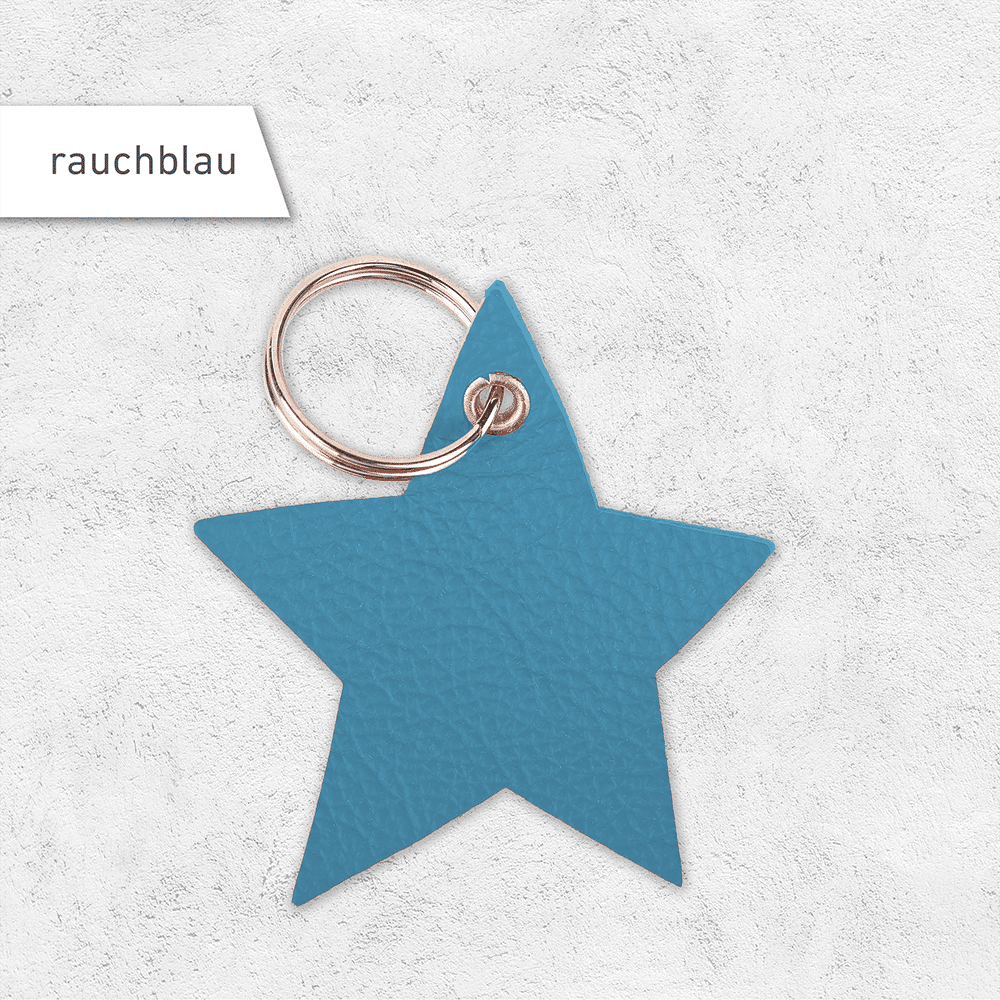 Ein Schlüsselanhänger in Sternenform aus Leder in der Farbe rauchblau.