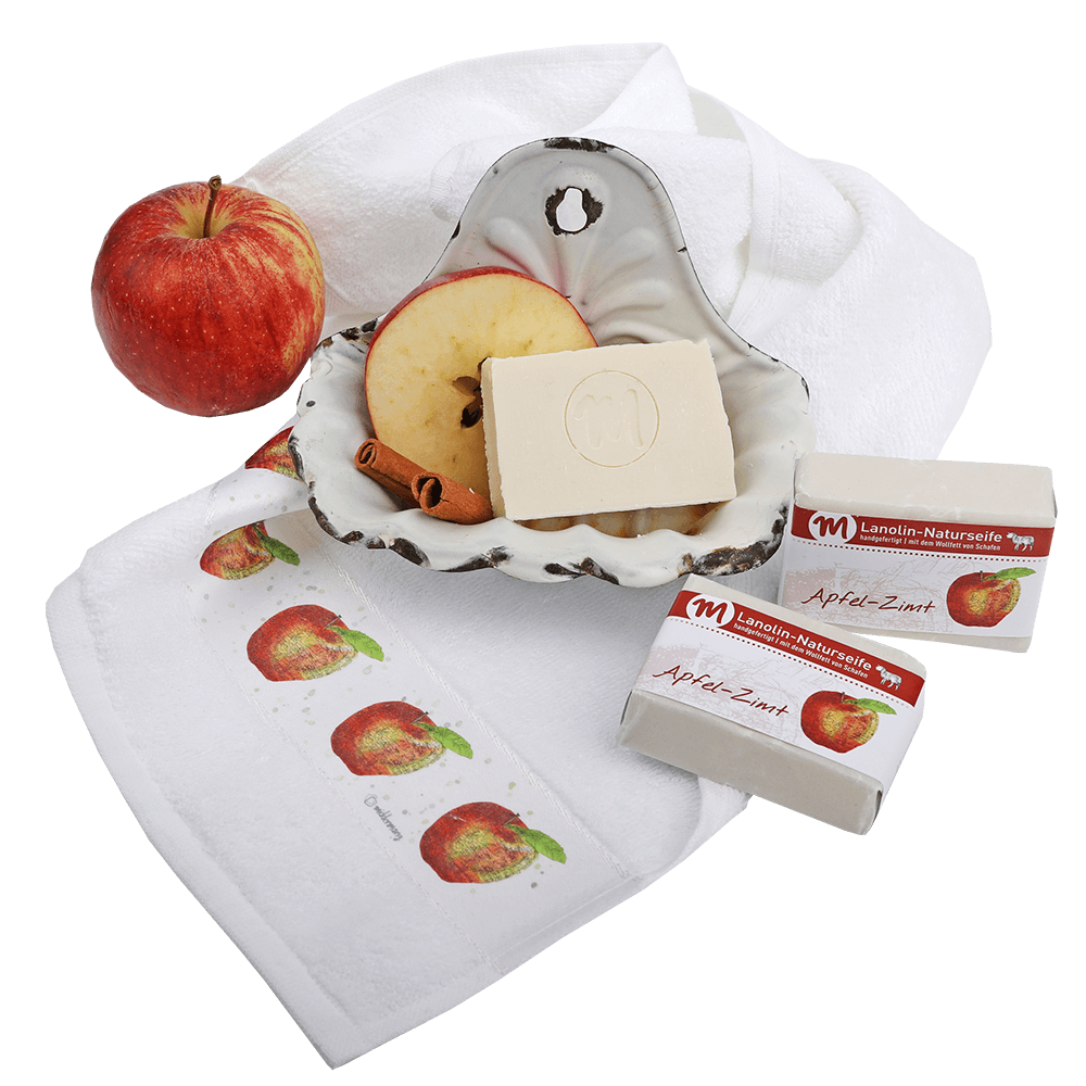 Drei Stücke Lanolin-Naturseife in Apfel-Zimt, auf Gästehandtuch bedruckt mit Apfel.