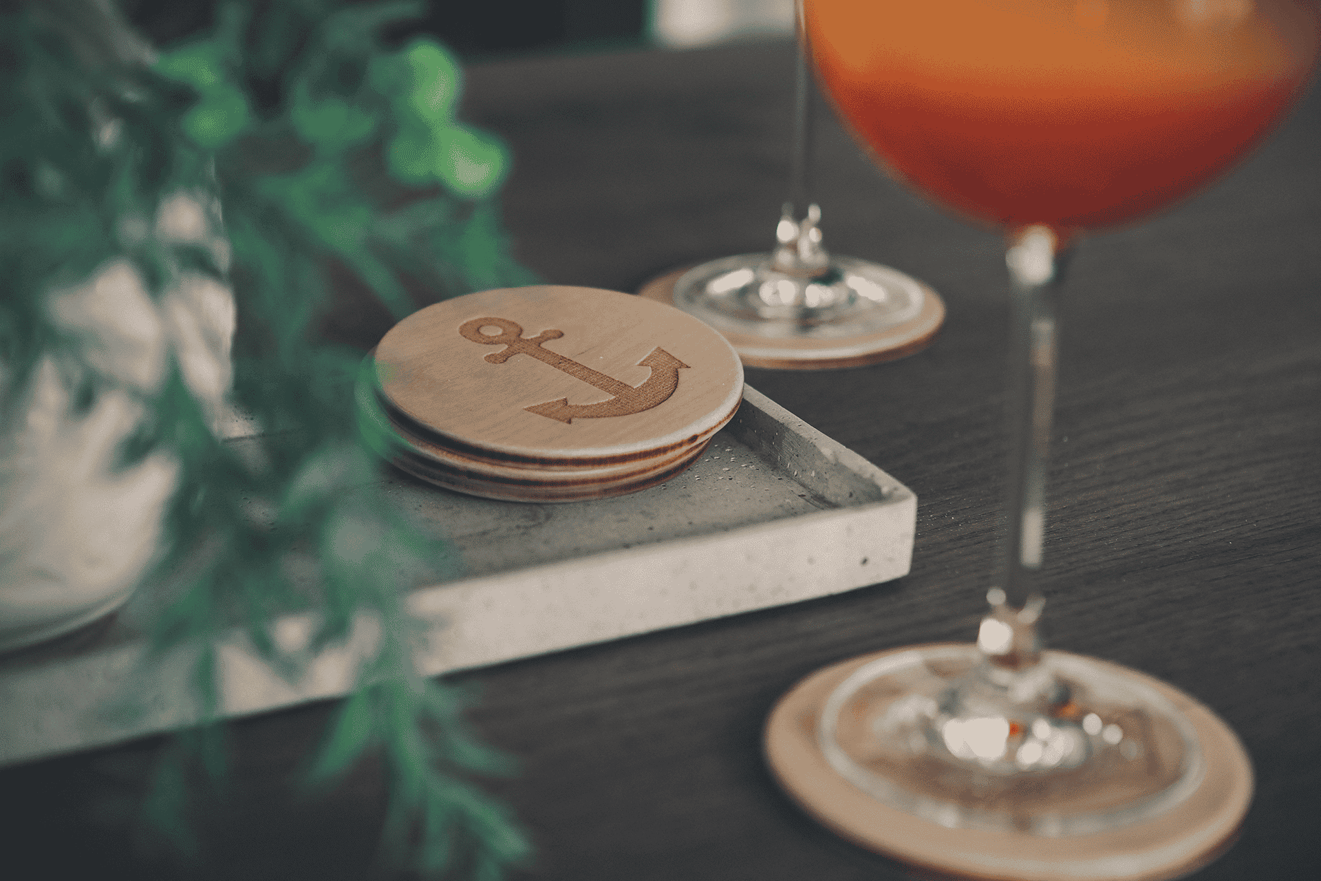 Untersetzer aus Holz mit Anker-motiv auf dekoriertem Tisch.