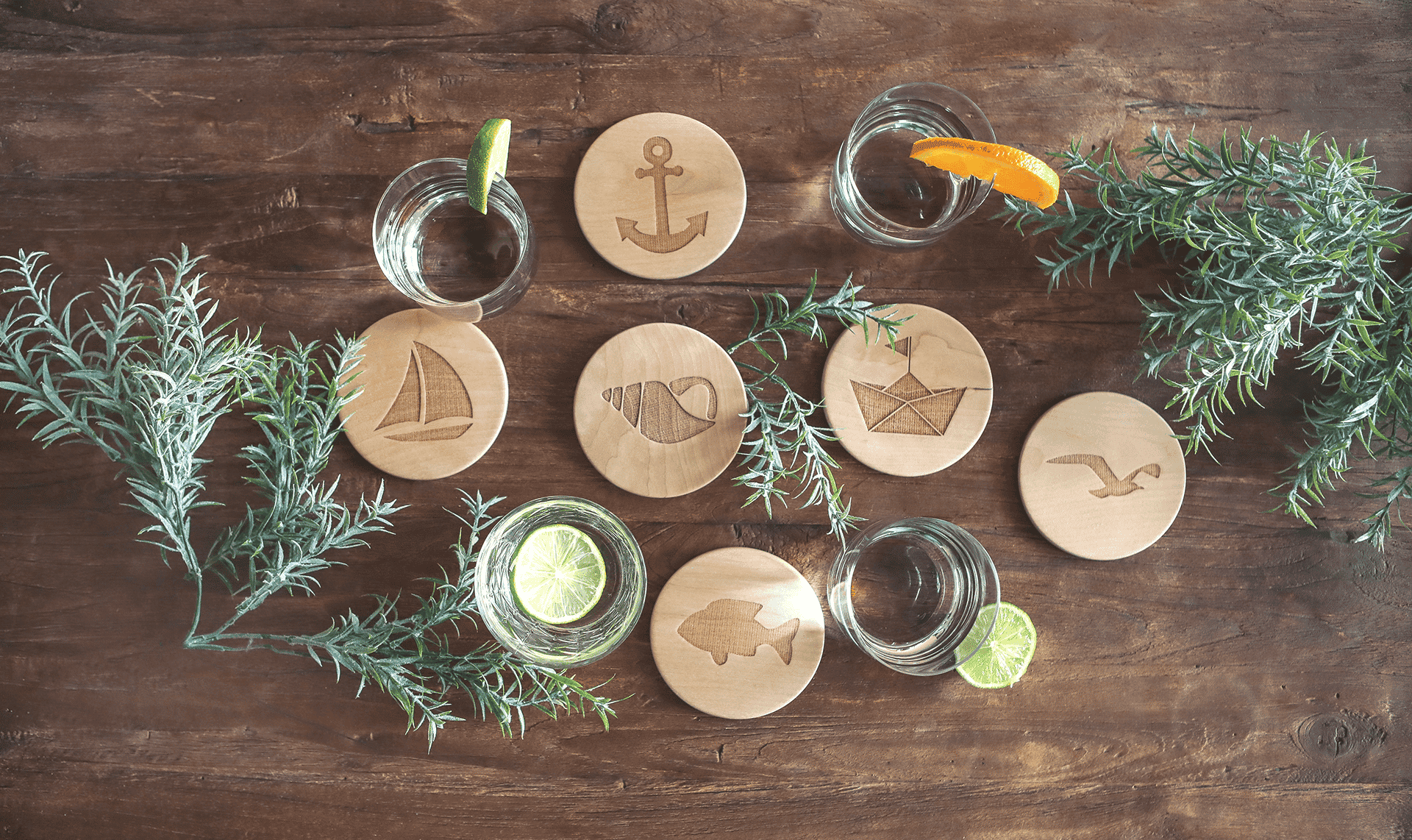 Unterschiedliche Untersetzer aus Holz mit maritimen Motiven, dekoriert auf einem Tisch.