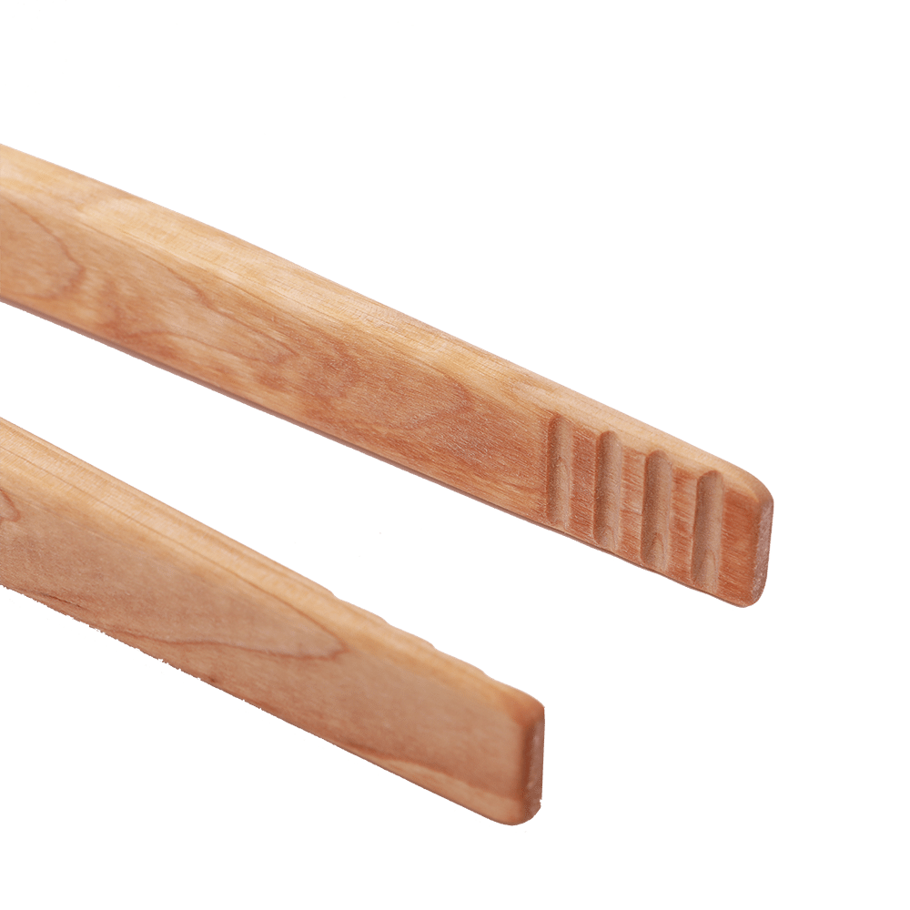 Geriffeltes Ende einer Grillzange aus Holz.