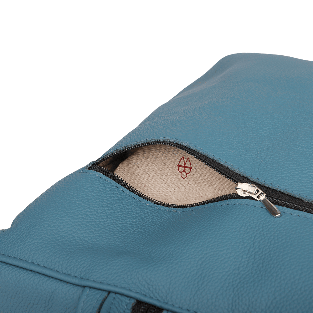 Ein kleiner Rucksack aus Leder in der Farbe rauchblau mit geöffneter Tasche.
