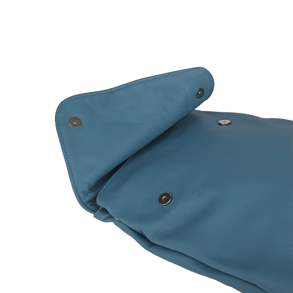Die Druckknöpfe eines kleinen Rucksacks aus Leder in der Farbe rauchblau.