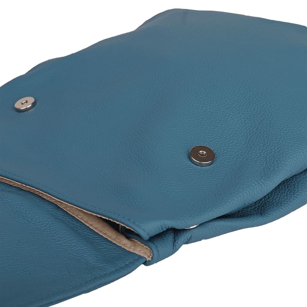 Die Druckknöpfe eines kleinen Rucksacks aus Leder in der Farbe rauchblau.