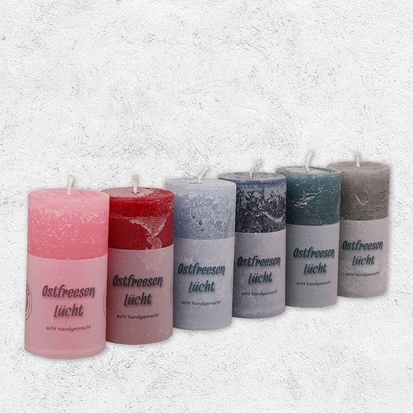 Diverse rustikale runde Kerzen mit der Aufschrift Ostfreesen Lücht in diversen Farben.