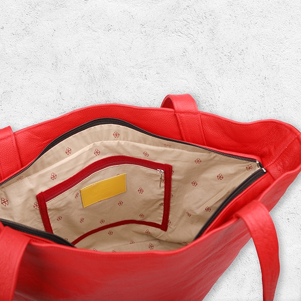 Eine Handtasche aus Leder in der Farbe corallrot von innen.