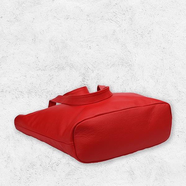 Eine Handtasche aus Leder in der Farbe corallrot von unten.