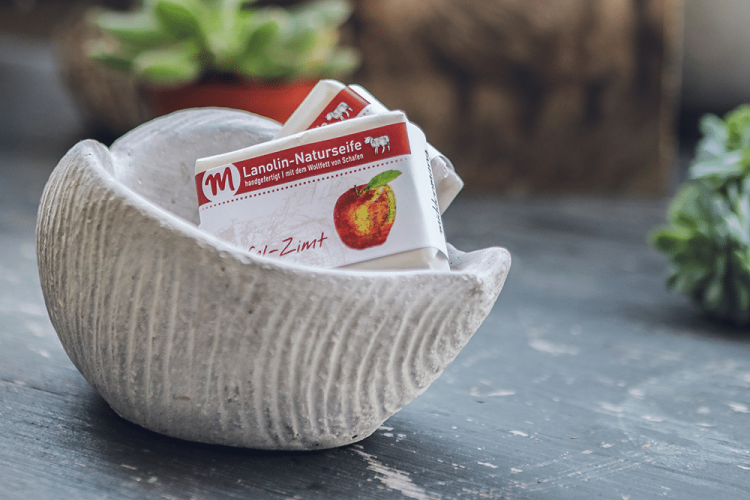 Lanolin-Naturseife mit Apfel-Zimt-Duft, in einer Schale in Muschelform.